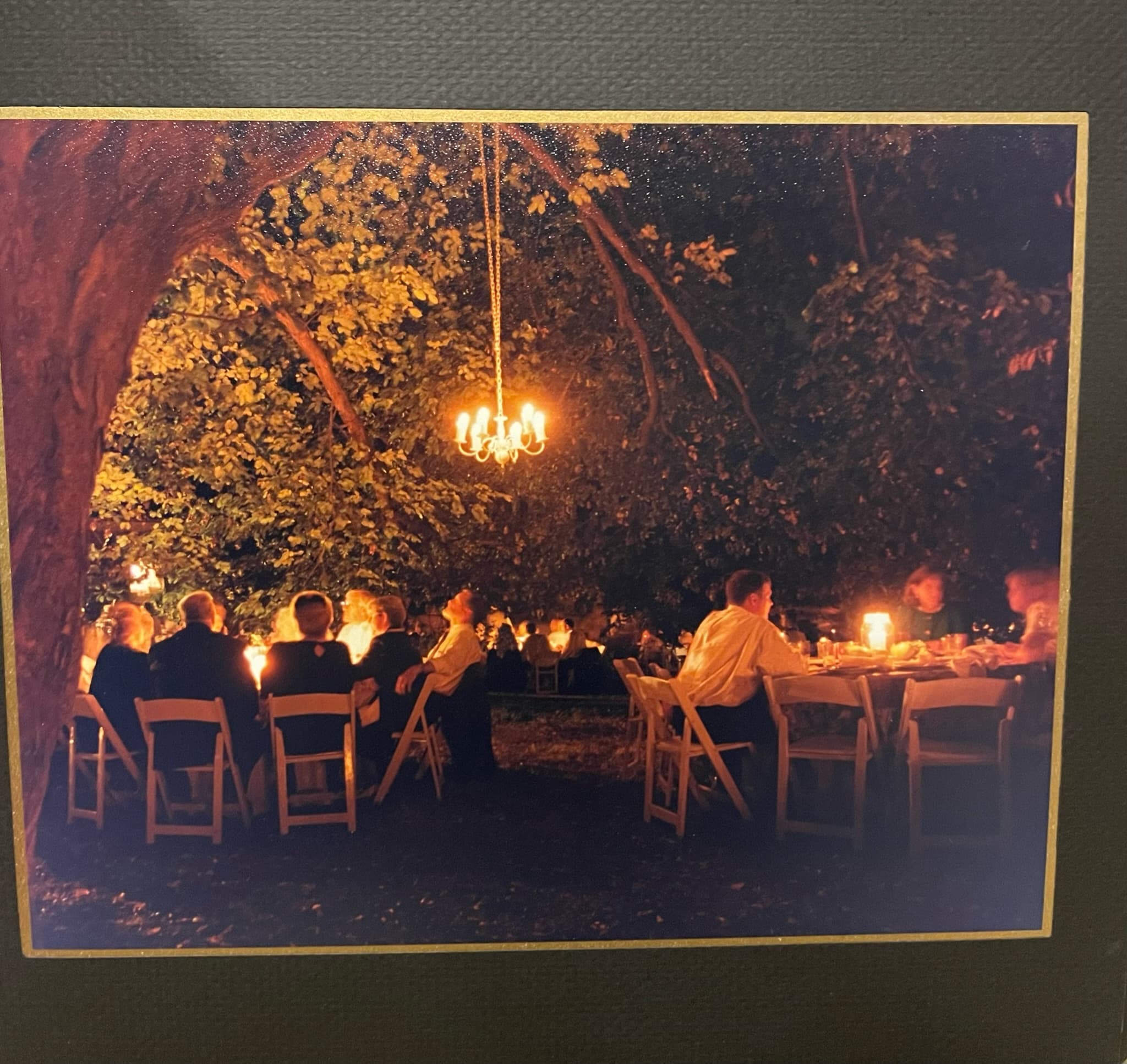Candlelit reception under towering magnolia trees at dusk