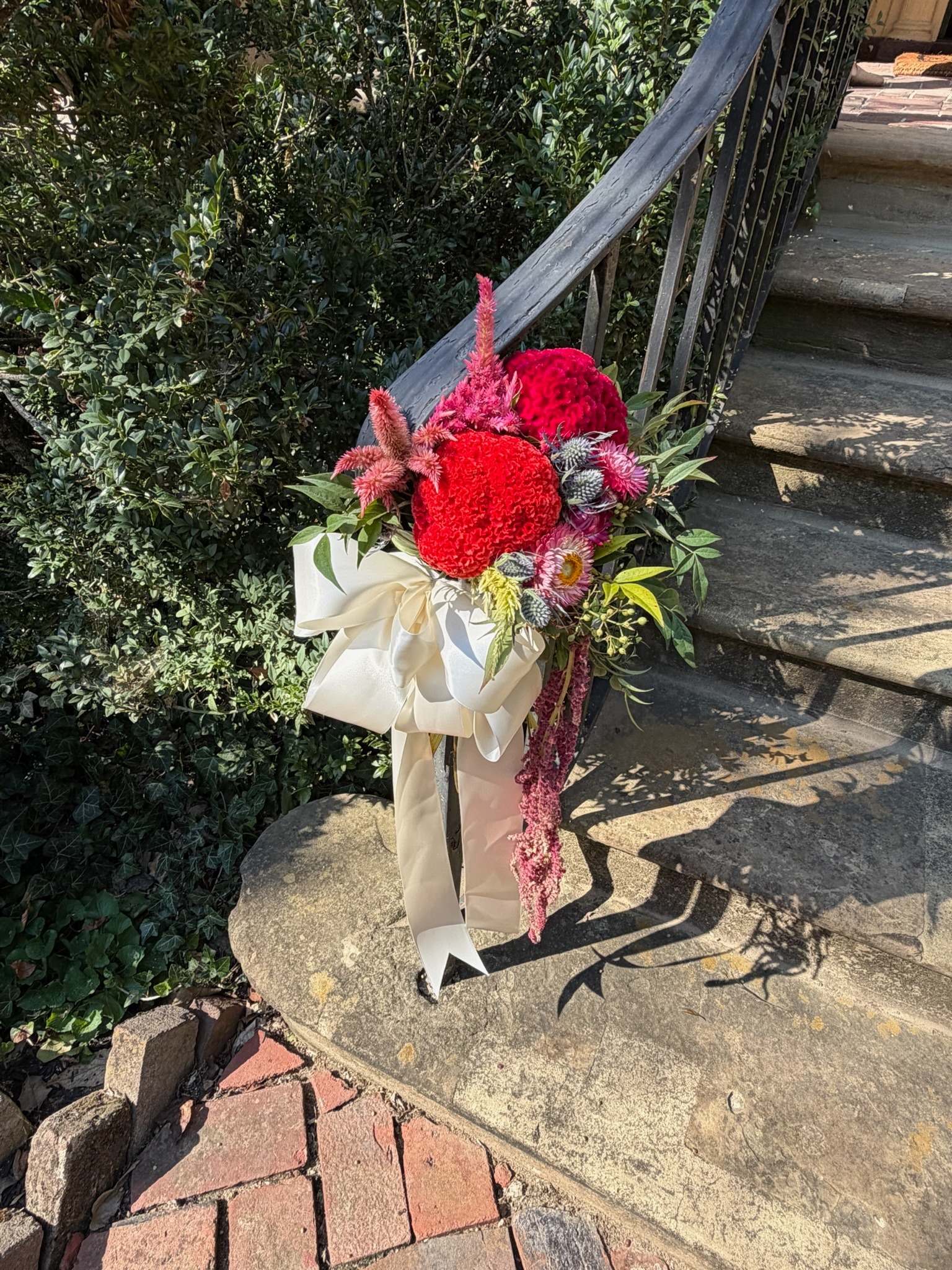 Red and pink flowers with an ivory ribbon decorating Ridgeway’s front steps